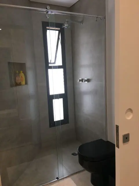 Banheiro com porta de correr no box Projeto de Susana Requião