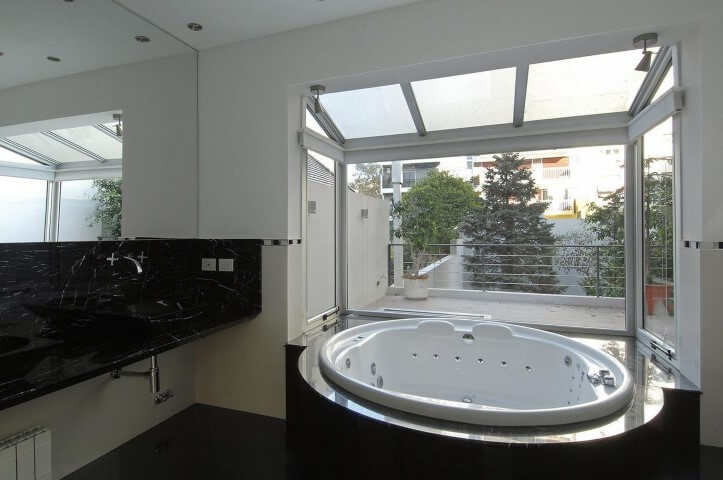 Banheiro de luxo com acabamento em vidro para entrada de luz natural Projeto de Estudio Sespede