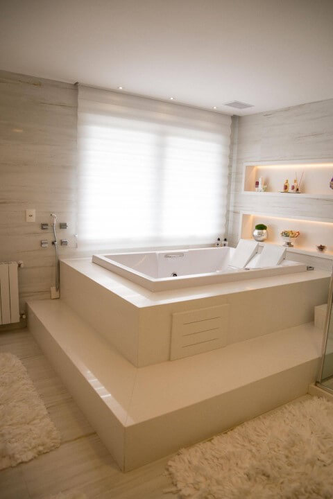 Banheiro de luxo com banheira branca Projeto de Joana Emanoela