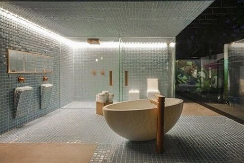 Banheiro de luxo com banheira e detalhes em cobre Projeto de Brunete Fraccaroli