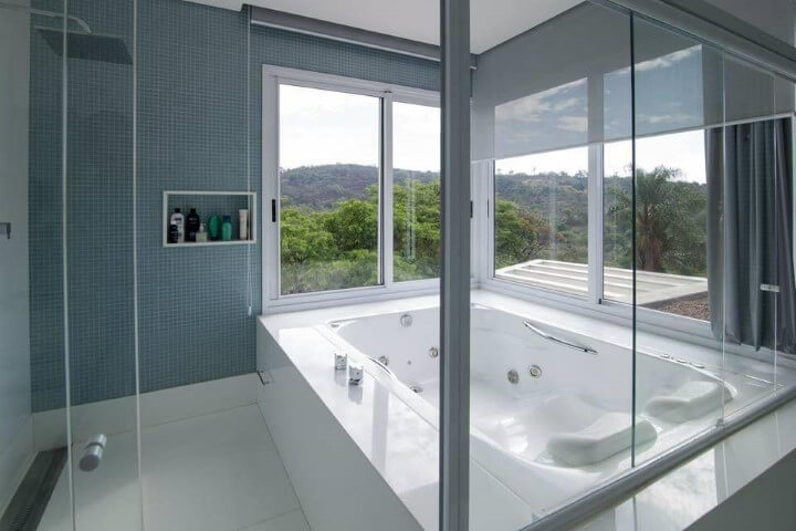 Banheiro de luxo com banheira e janelas amplas Projeto de Mutabile
