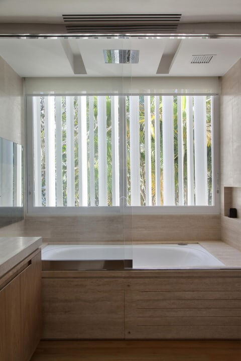 Banheiro de luxo com banheira revestida com madeira Projeto de Gisele Taranto