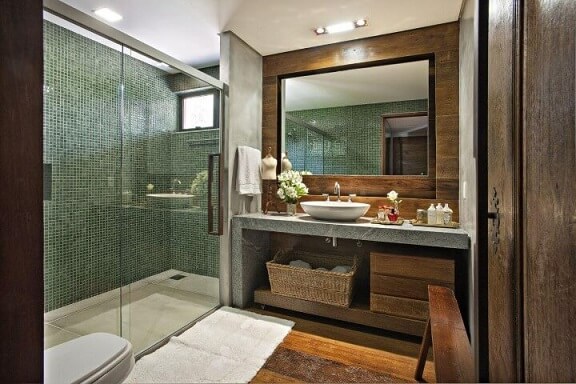 Banheiro de luxo com pastilha verde e revestimento de madeiara Projeto de Gislene Lopes