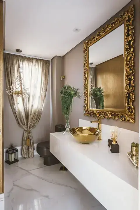 Banheiro de luxo com peças douradas Projeto de Daniela Gradella