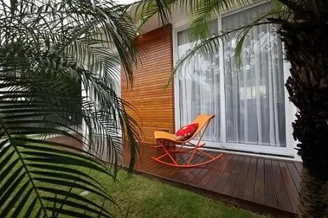 Casa com varanda com cadeira de balanço Projeto de Cristina Rei