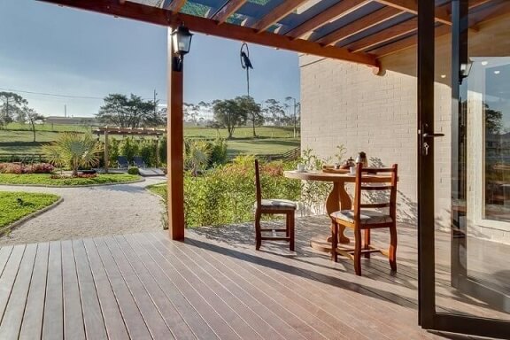 Casa com varanda com mesa redonda pequena Projeto de Juliana Lahoz