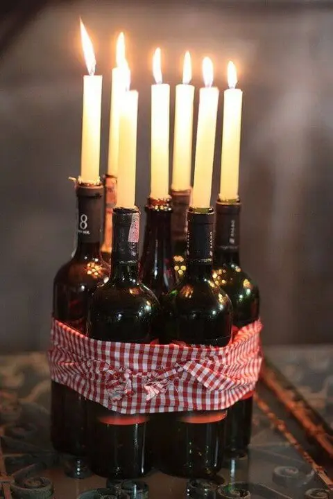 Decoração de aniversário simples com garrafas de vinho com velas