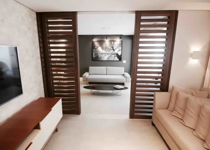 Sala de estar com porta de correr de madeira com brises Projeto de Glaucio Gonçalves