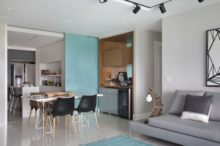 Sala de jantar e cozinha separadas por uma porta de correr azul Projeto de Fernanda Azevedo Mancini