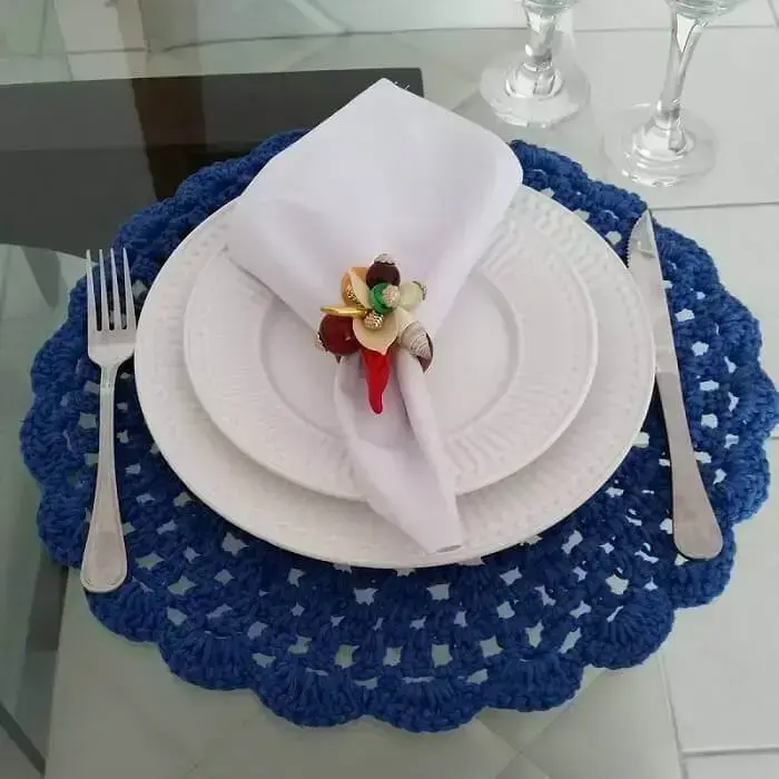 Sousplat de crochê azul com pratos brancos