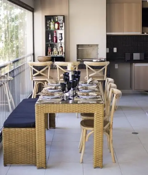 Varanda com churrasqueira com balcão e mesa Projeto de Madi Arquitetura