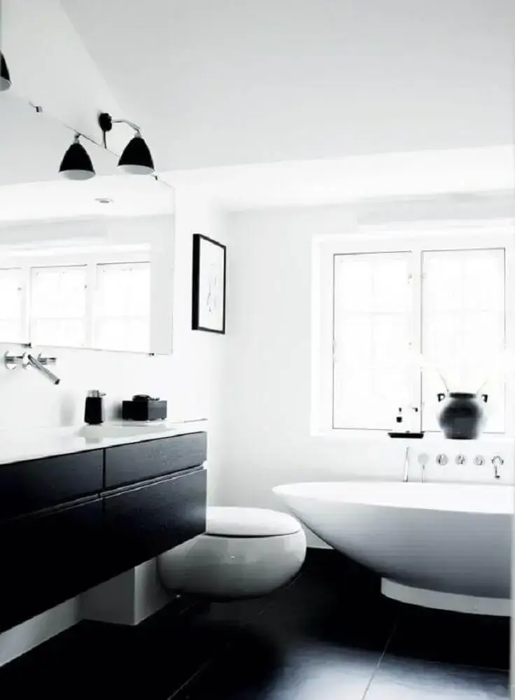 banheiro preto e branco com banheiro e luminária