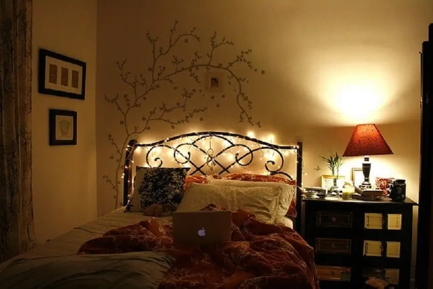 cabeceira de cama com pisca pisca e adesivo de árvore