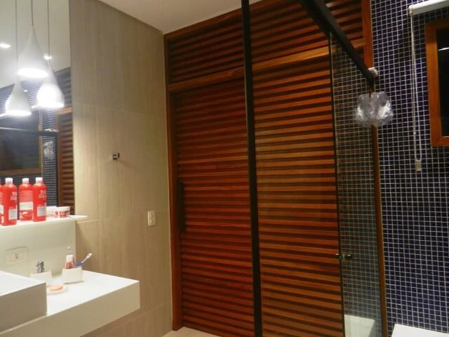 Sala de banho com porta de correr de madeira Projeto de Paula Freitas