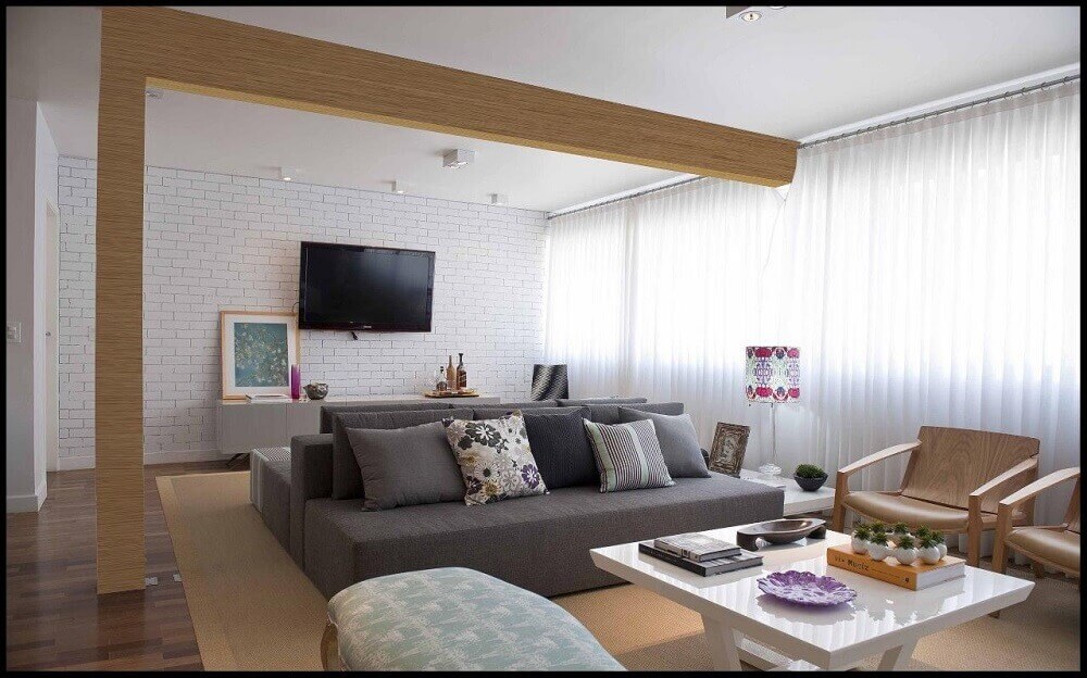 Decoração simples em sala com sofá cinza e mesa de centro branca