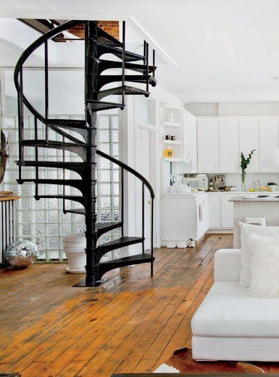 Sala de estar clean e branca com escada de ferro preta