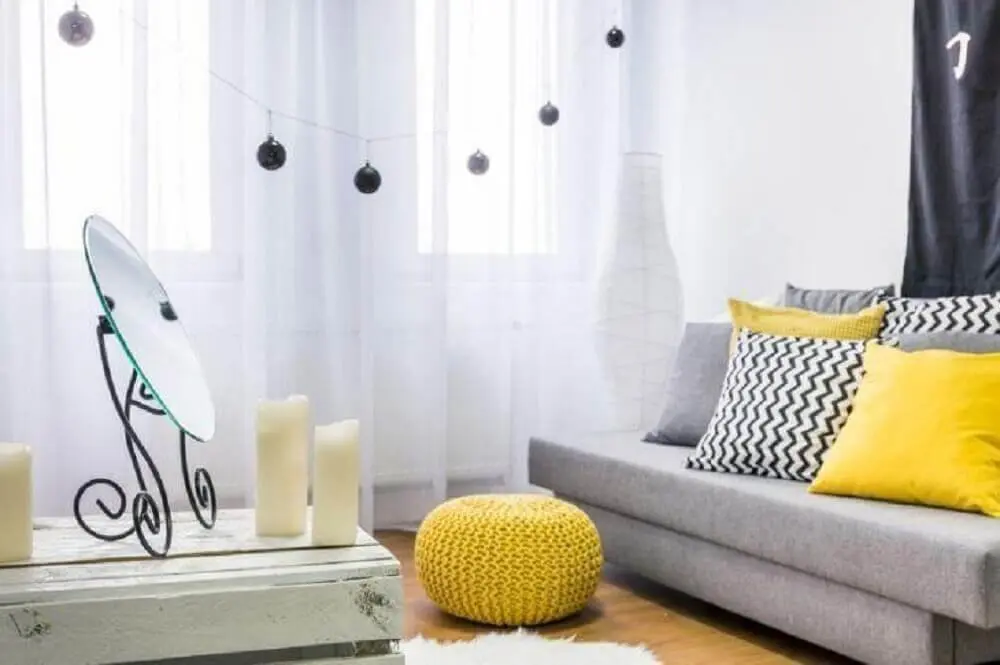 sala com sofá cinza e almofadas amarelas