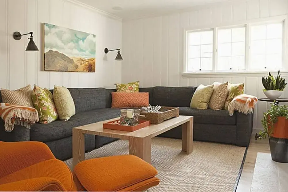 sala com sofá de canto cinza e almofadas estampadas