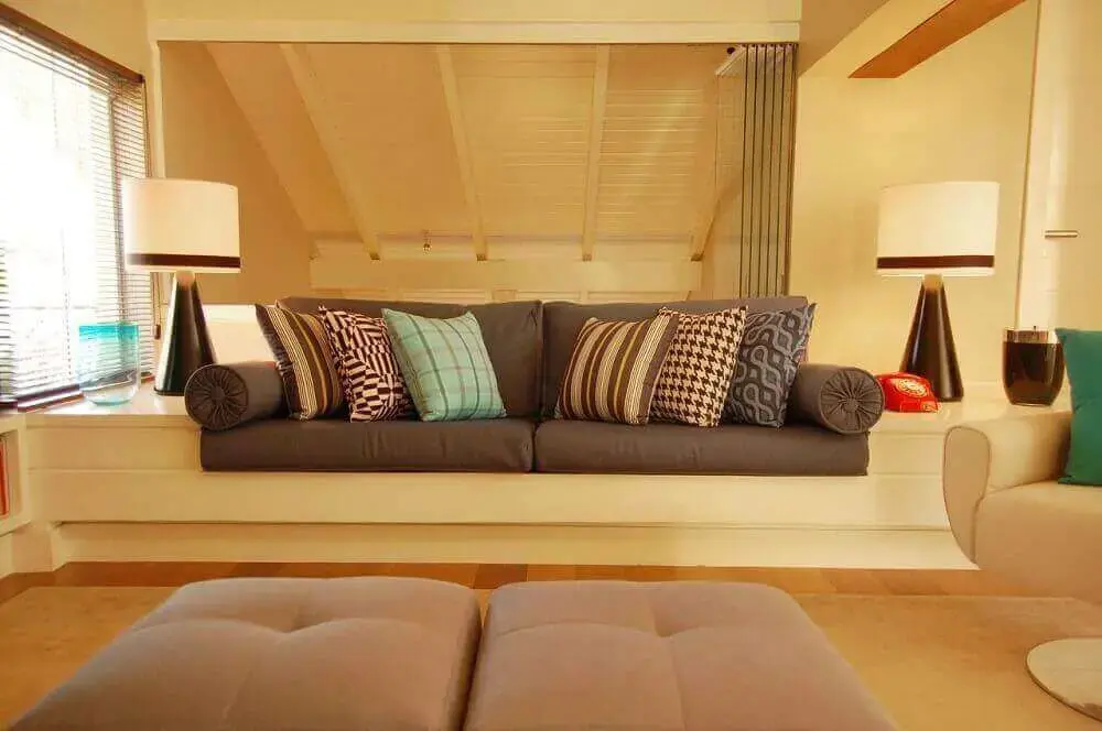 Sala com sofá marrom e almofadas estampadas