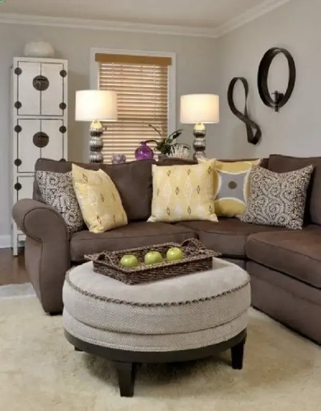 sala com sofá marrom e almofadas amarelas estampadas