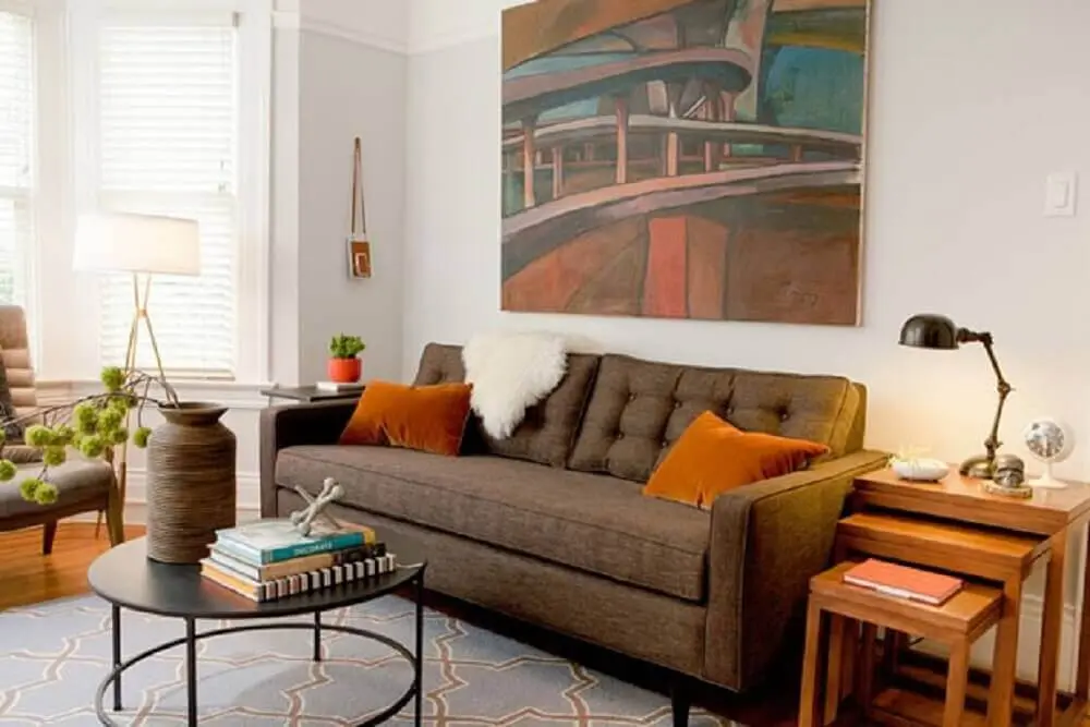 sofá marrom com almofadas laranja e manta peluda