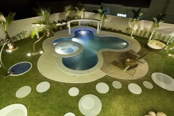Área de lazer com piscina e espreguiçadeiras Projeto de Aquiles Nicolas Kilaris