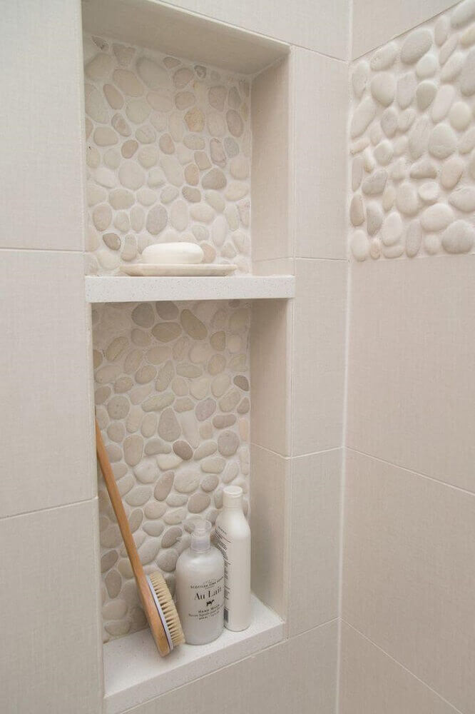 banheiro com nicho embutido e com revestimento de pedra