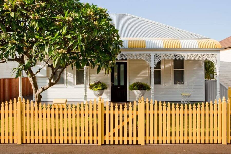 casa com cerca de madeira amarela