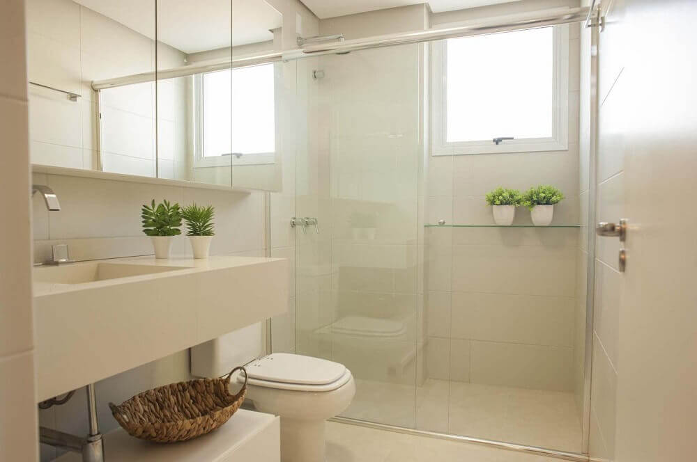 Modelo de banheiro simples com cores claras e pequenos vasos com plantas