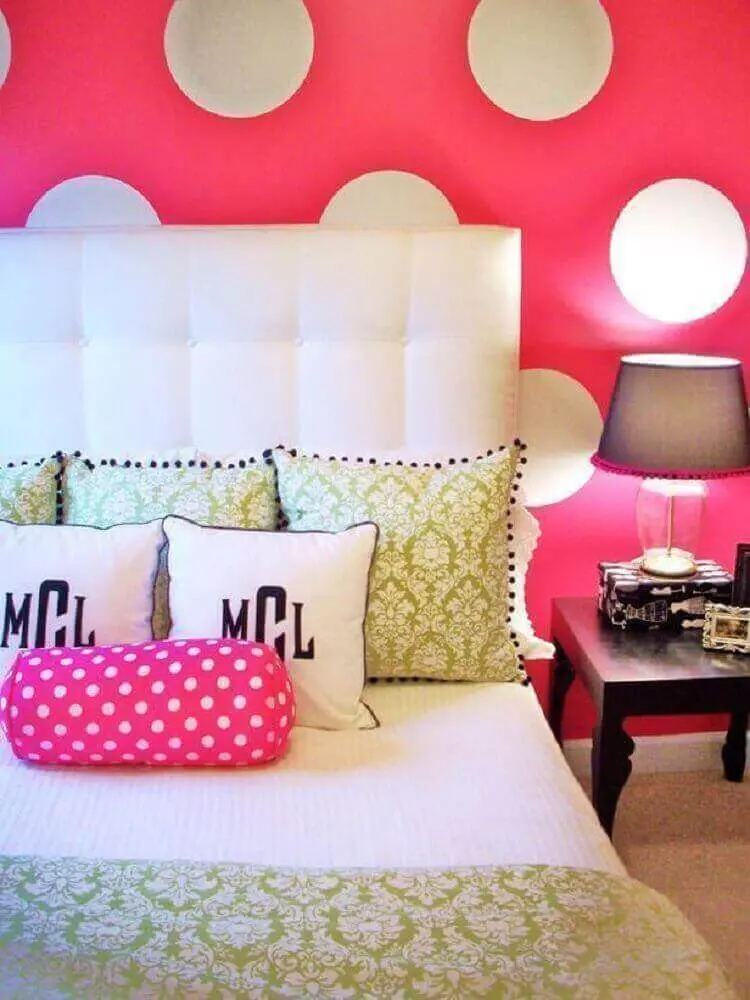 decoração de quarto feminino com cabeceira branca e papel de parede pink com bolinhas brancas