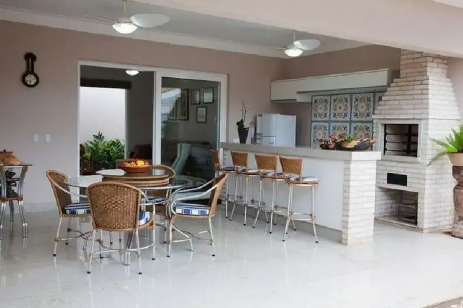 espaço gourmet decorado com mesa redonda e churrasqueira de alvenaria Foto Fantin & Siqueira - Arquitetura e Decoração