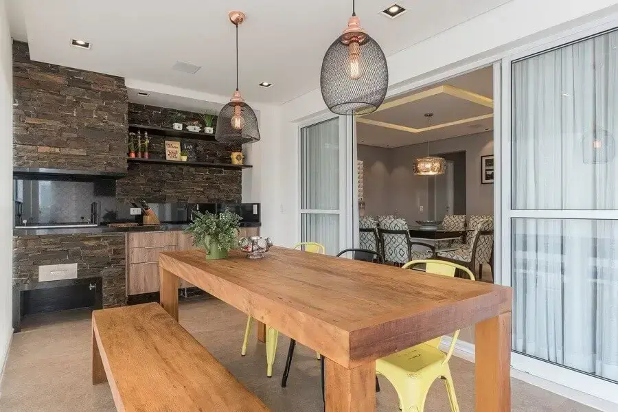 espaço gourmet pequeno decorado com mesa de madeira e revestimento rústico Foto Idealizzare Arquitetos