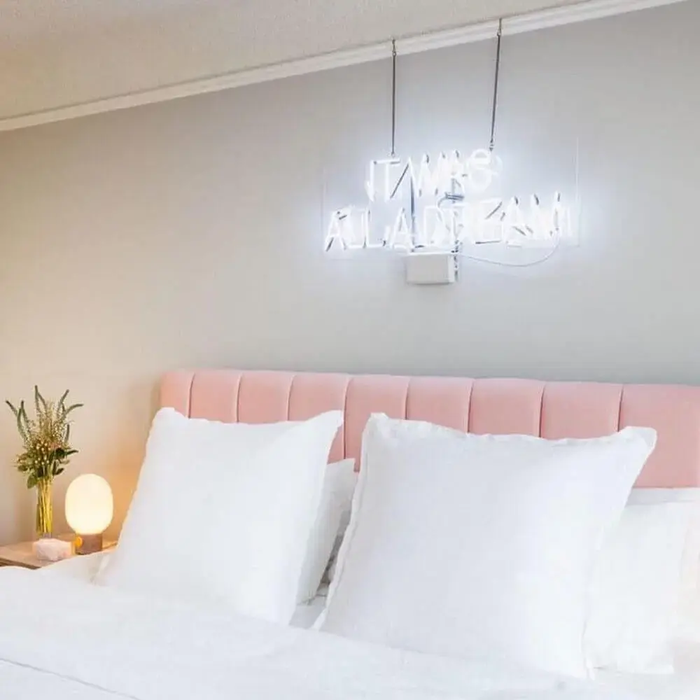 quarto decorado com cabeceira estofada rosa e luminária sobre a cama Foto New Home Designs