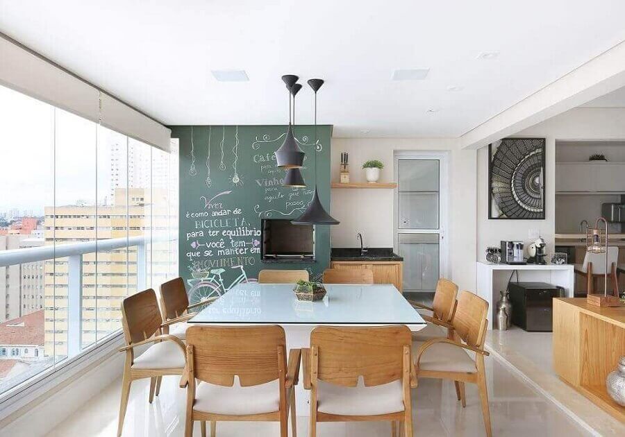 Área gourmet moderna para apartamento decorado com parede de tinta lousa e mesa quadrada Foto Renata Cafaro