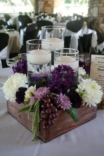Centro de mesa de casamento rústico com velas e flores