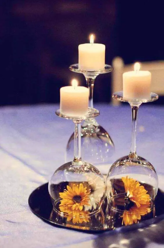 Centro de mesa de jantar com taças, girassois e velas