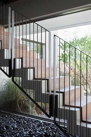 Escada de ferro com degraus de concreto e madeira Projeto de Consuelo Jorge