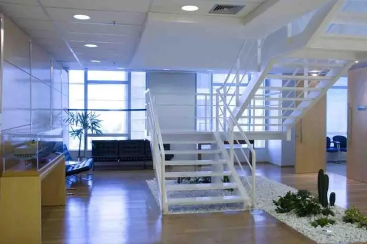 Espaço comercial com escada de ferro branco Projeto de Artiun Arquitetura