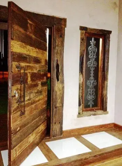 Porta de entrada pivotante de madeira de demolição Projeto de Martha Lilianne Grucci