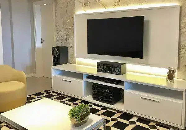 Revestimento de parede em mármore traz requinte para a sala de TV. Fonte: Estela Cislaghi Arquitetura