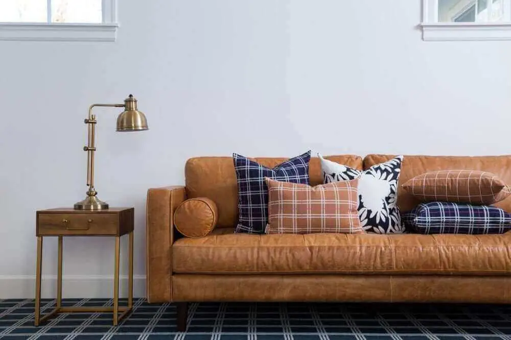 decoração com sofá de couro para sala com muitas almofadas