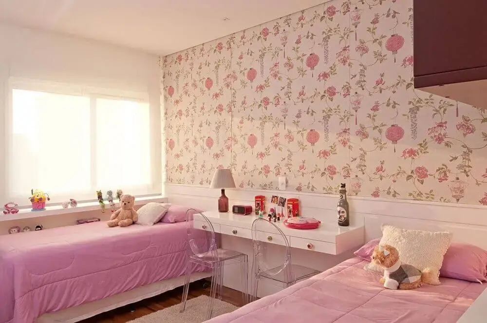 decoração de quarto infantil feminino com papel de parede floral e cadeiras de acrílico transparente
