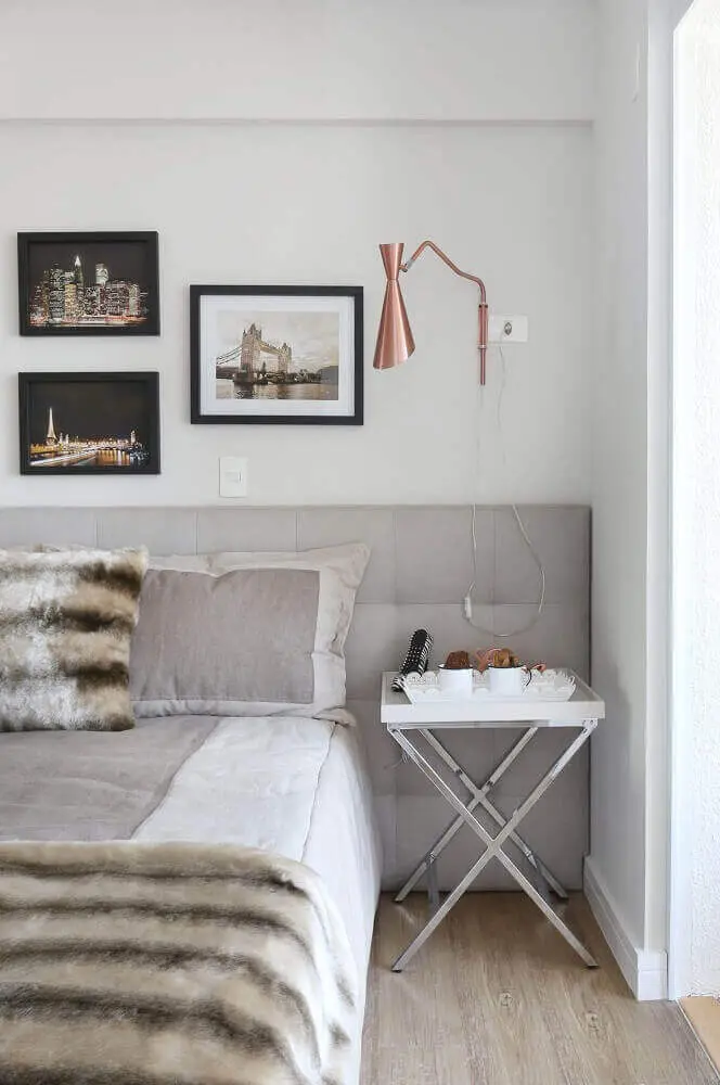 Decoração de quarto minimalista com luminária cobre e cabeceira cinza