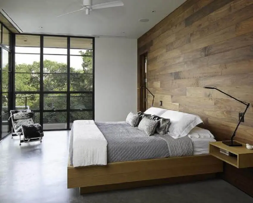 quarto de casal com decoração minimalista e revestimento de madeira