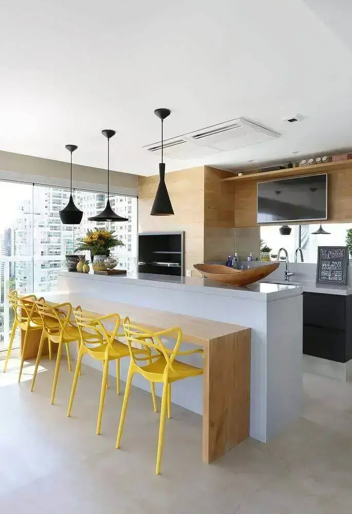área gourmet moderna com cadeiras amarelas e luminária preta