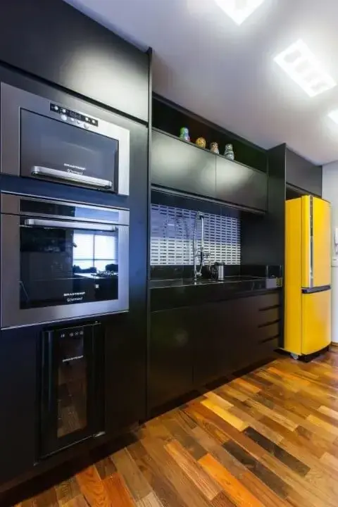 Armários pretos e geladeira colorida amarela Projeto de MC3 Arquitetura
