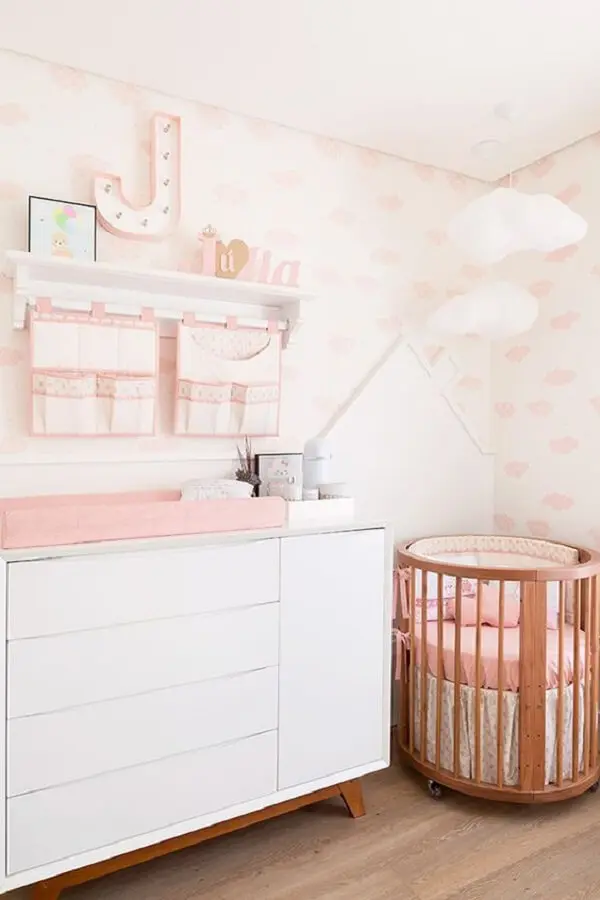 Berço redondo de madeira e cômoda retrô decoram o quarto de bebê. Fonte: Constance Zahn