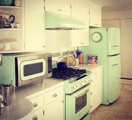 Cozinha com móveis brancos e geladeira colorida duplex verde