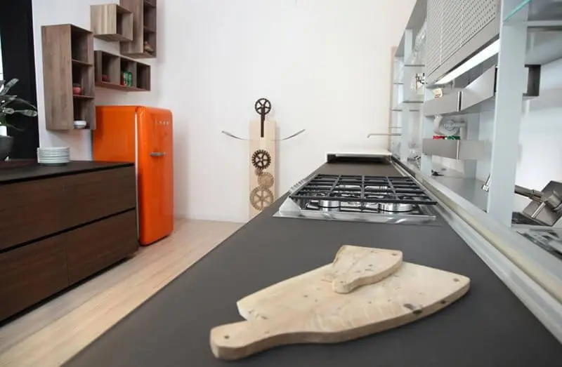 Cozinha com móveis marrons e geladeira colorida laranja Projeto de Fabiana Rosello