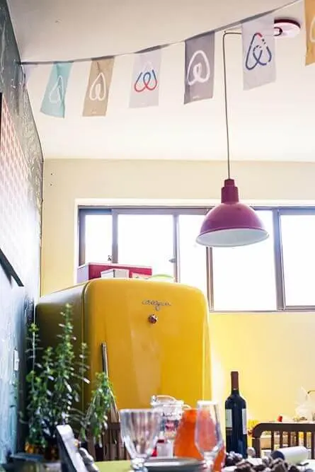 Cozinha simples com geladeira colorida amarela e luminária vermelha Projeto de Casa Aberta